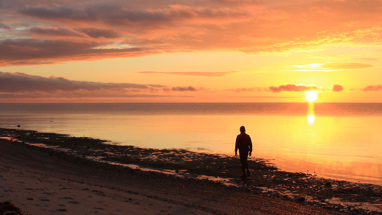 Solitary person along the beach at sunset