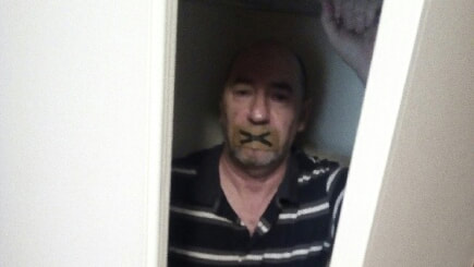 Tony in a closet with his mouth taped